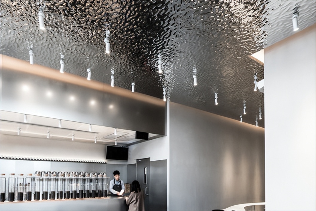Water ripple stainless steel ceiling installed in a high-end restaurant with floor-to-ceiling windows